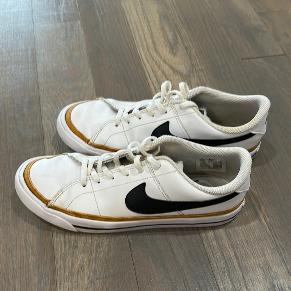 Nike Youth White Low-Top Sneakers with Black Swoosh and Gold Trim